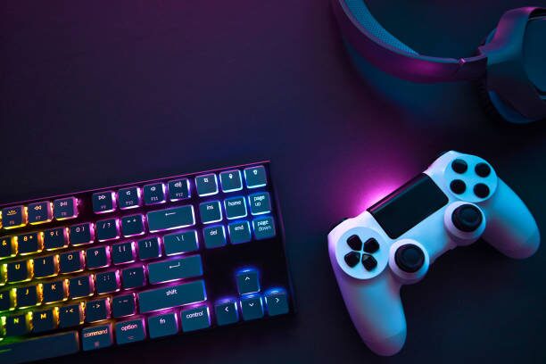 Imagen de un mando de consola al lado de teclado RGB